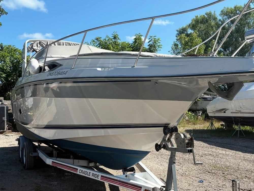 NexGen Auto Transport performing overland boat transport with a specialized tow rig moving a large sailboat across state highways.